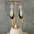 Aretes Copo de nieve · Dorado, negro y beige, tamaño mediano, colección Navidad